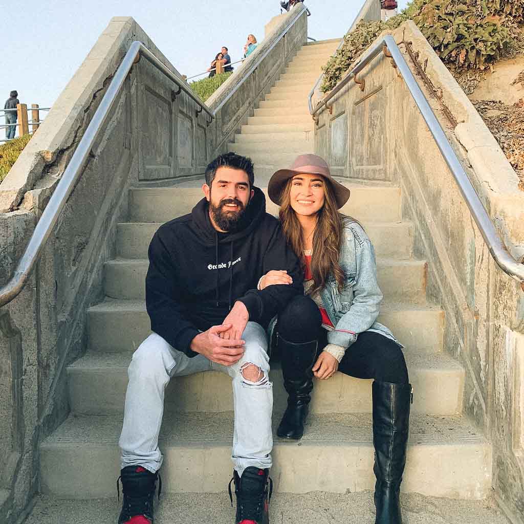 Steven and Jessica Cameron sitting on steps near the beach