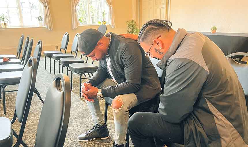 Two people praying at the Portland City Church prayer meeting.